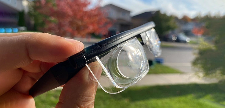 flex vision glasses man holding the glasses in his backyard